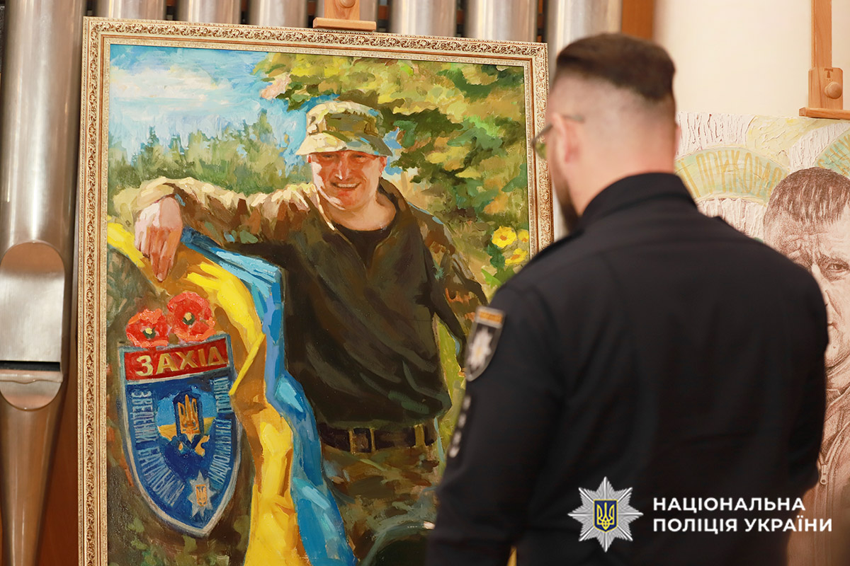 Поліцейський розглядає портрет загиблого захисника