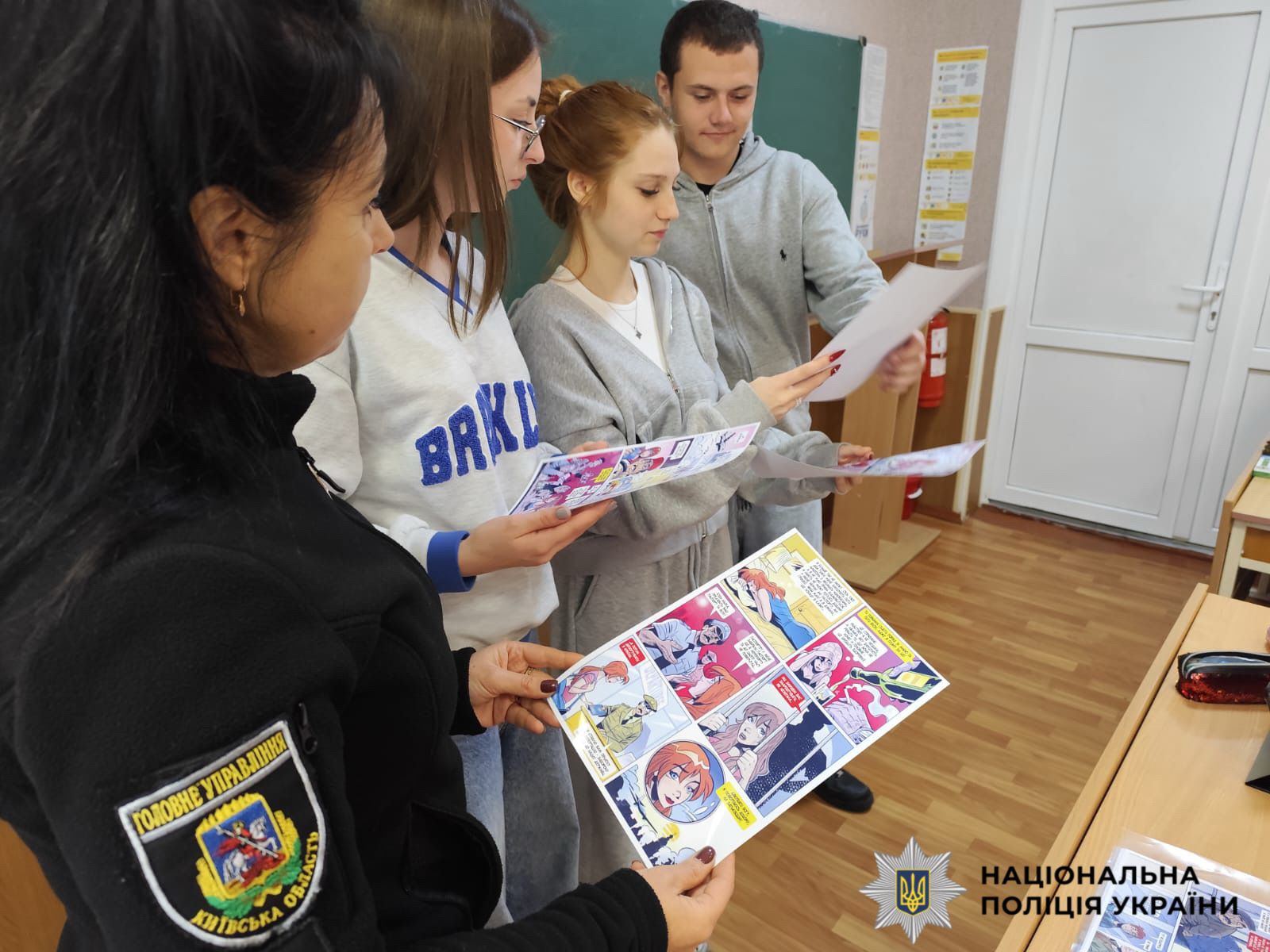 Поліцейська з діьтми біля дошки в класі.