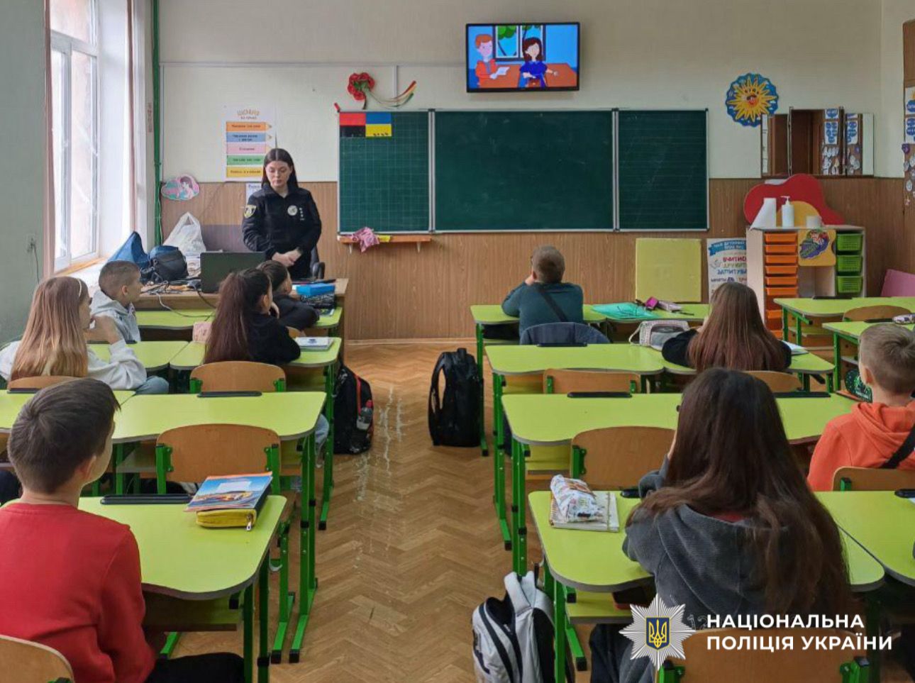 На фото поліцейська в класі проводить заняття.