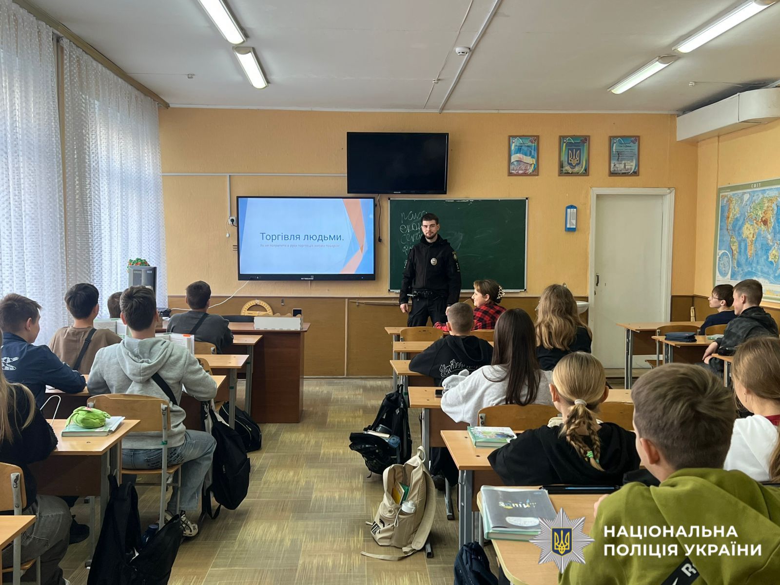 На фото поліцейська в класі проводить заняття.