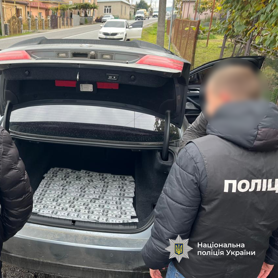 Поліцейські вилучають гроші, як речовий доказ у кримінальному провадженні щодо незаконного перетину кордону