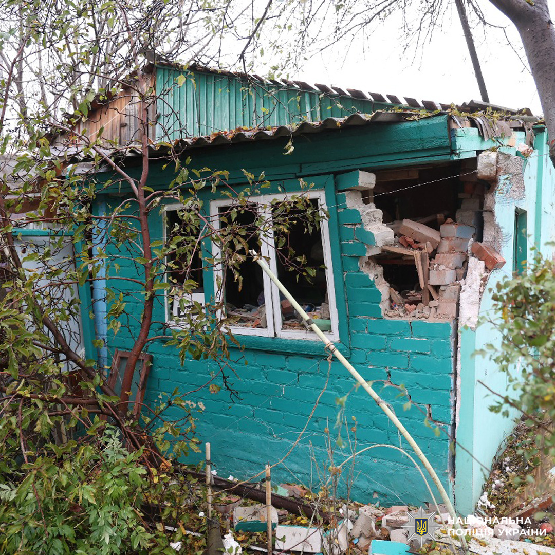 Пошкоджений житловий будинок з бірюзовим фасадом: обвалена стіна, зруйновані вікна, уламки, пошкоджений дах.