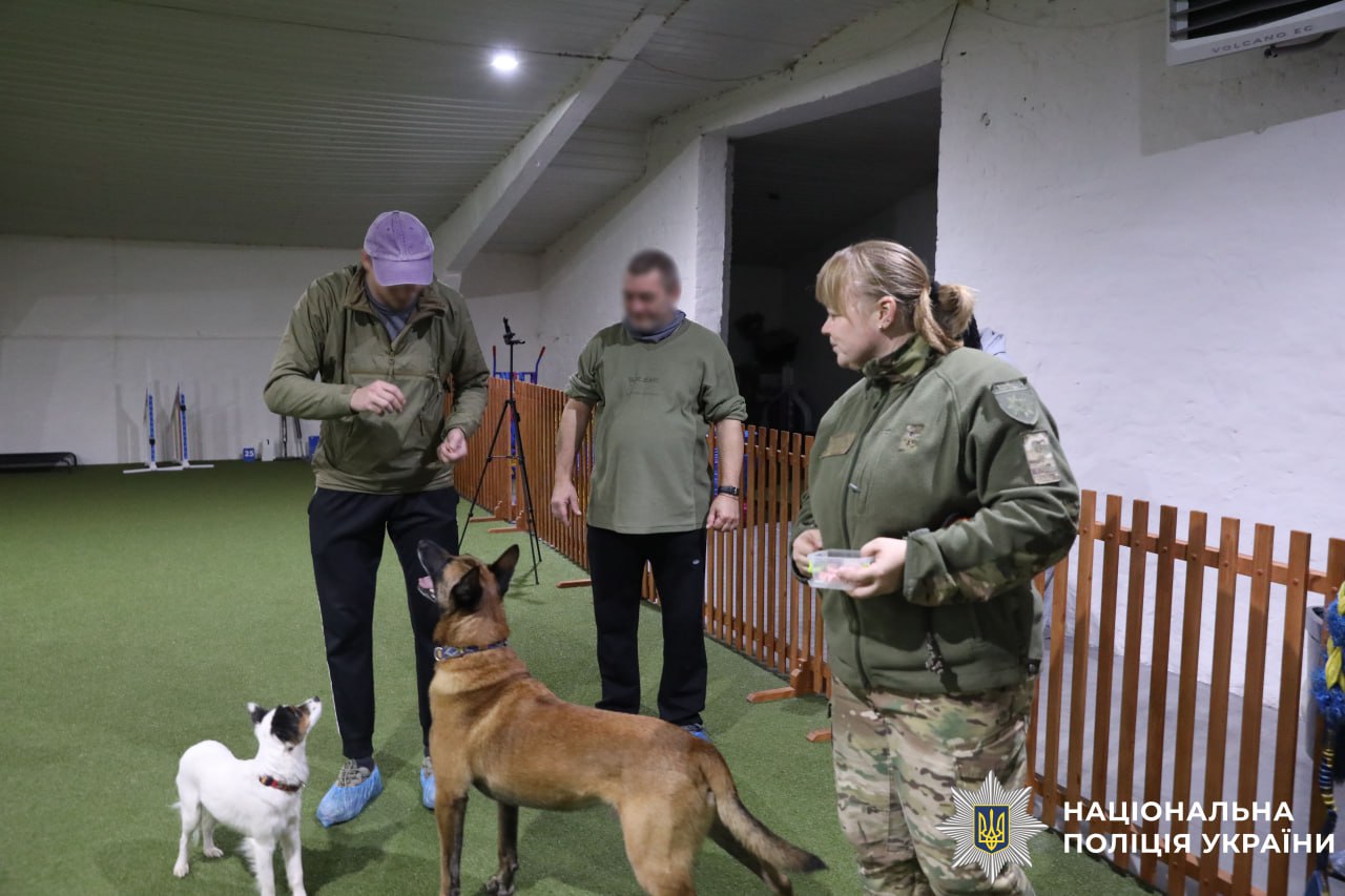 Фото, на якому собака виконує команду поліцейського.