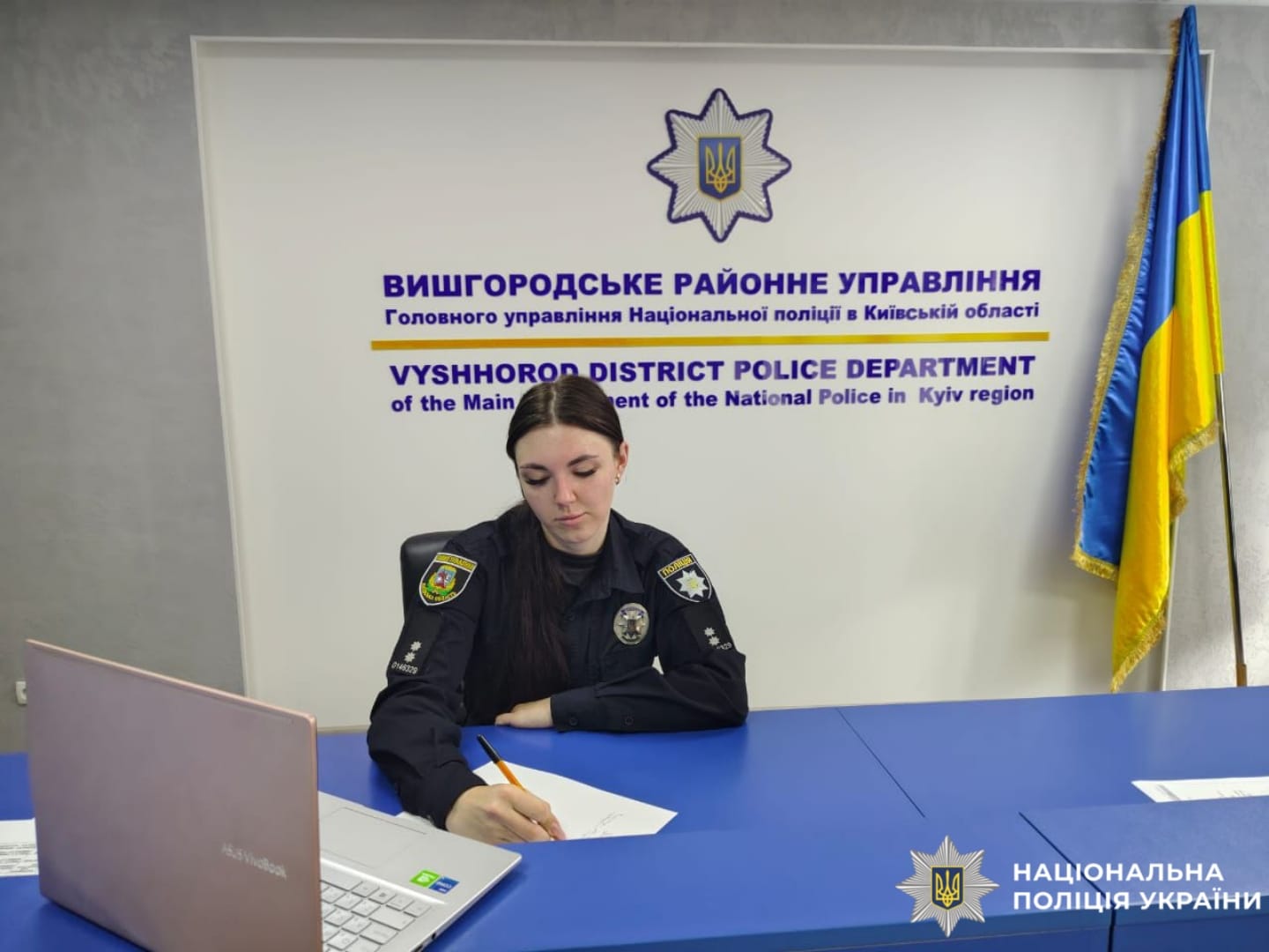 На фото поліцейська, яка пише диктант.