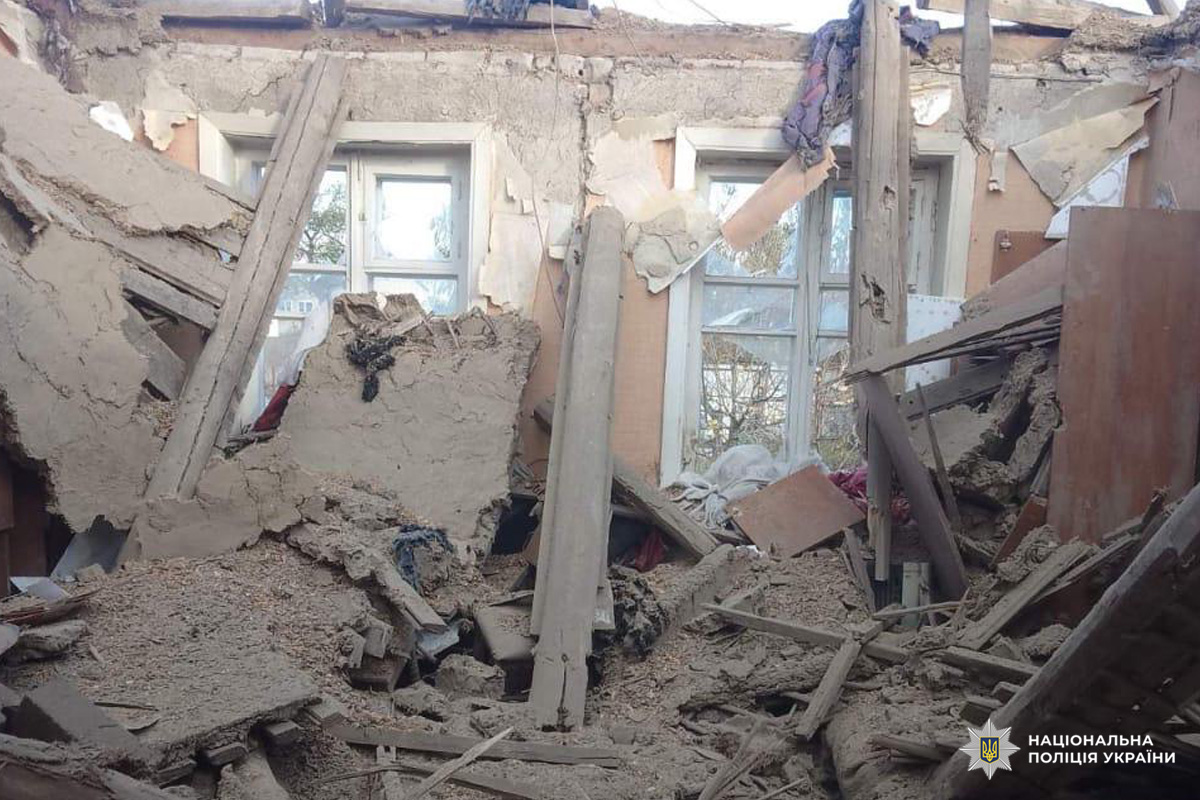 На фото серйозно пошкоджене приміщення: обвалені стіни та стеля, значна кількість уламків деревини, штукатурки та будівельних матеріалів. Вікна залишились цілими, що свідчить про локалізований характер руйнування.