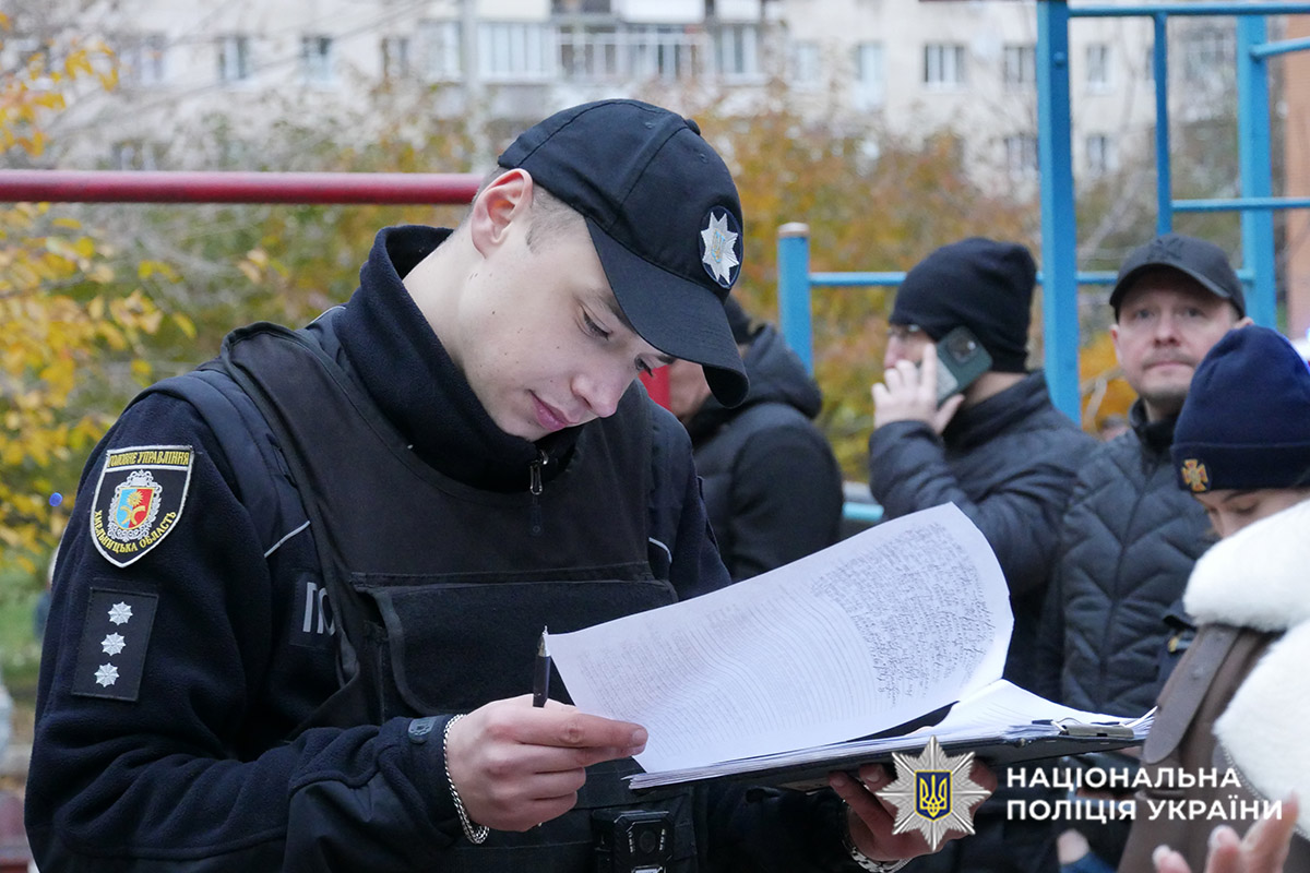 Поліцейський на місці вибуху у будинку пише протокол