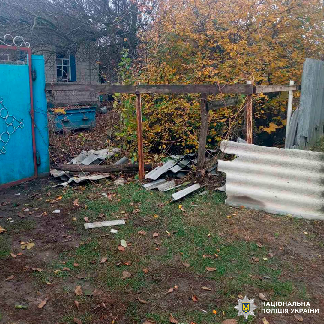 Пошкоджений паркан у житловому районі. Металеві листи та дерев’яна конструкція частково зруйновані.