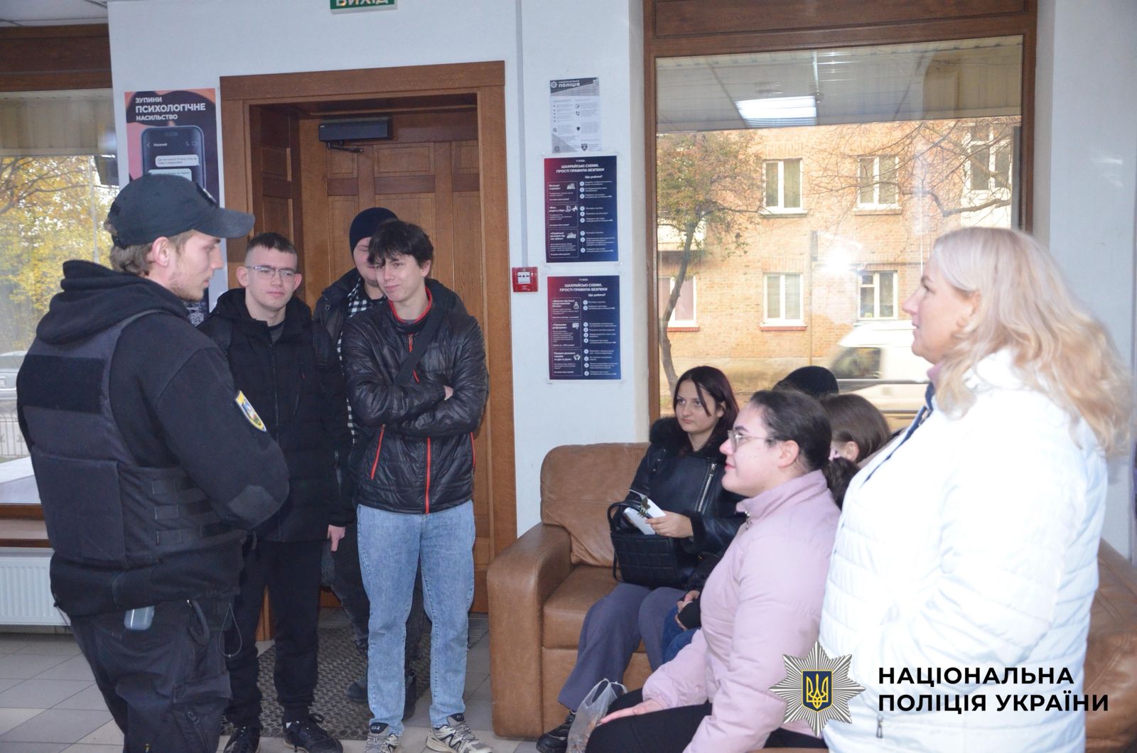 На фотографії зображено студенти, яким поліцейські розповідають про окремі напрямки служби в поліції.