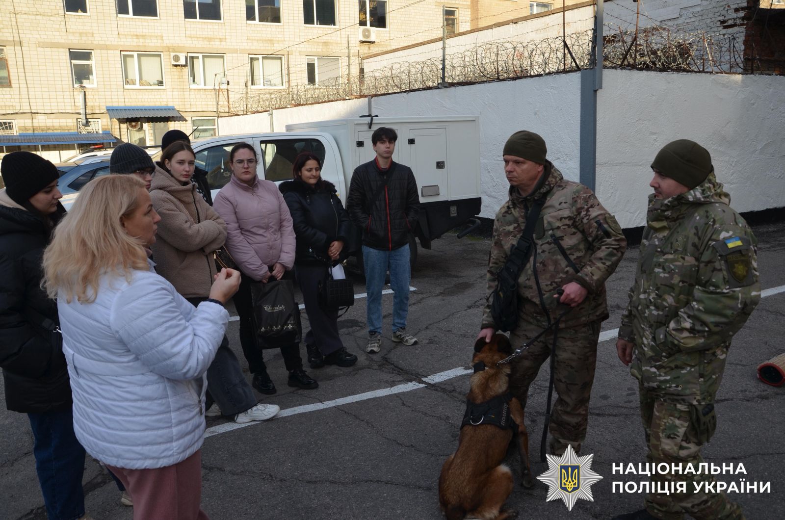 На фотографії зображено студенти, яким поліцейські розповідають про окремі напрямки служби в поліції.