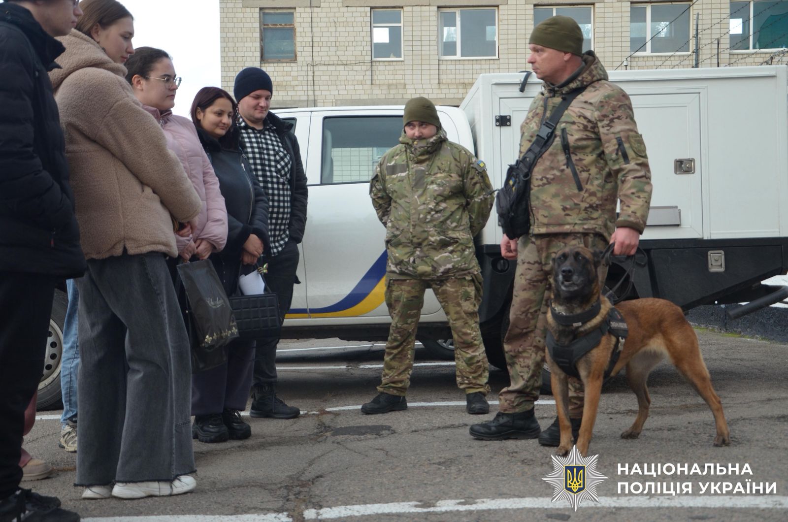 На фотографії зображено студенти, яким поліцейські розповідають про окремі напрямки служби в поліції.