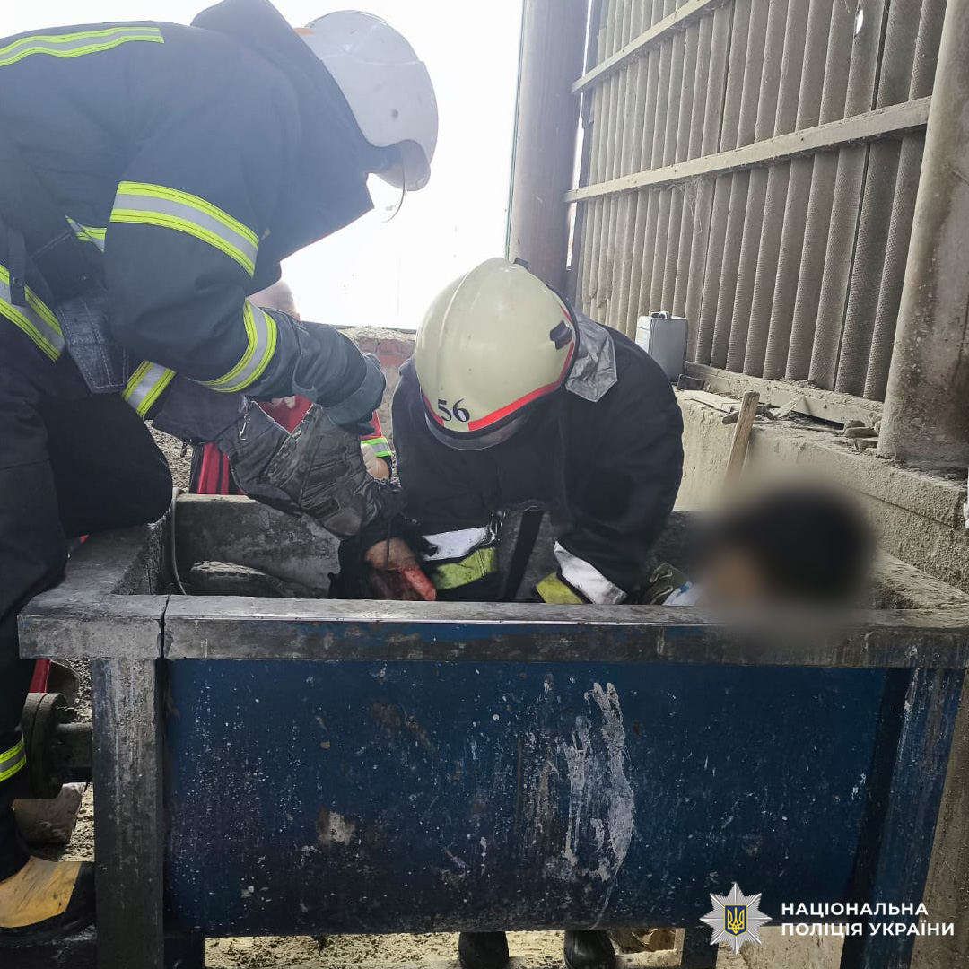 Співробітники аварійно-рятувальної служби у спеціальному спорядженні надають допомогу постраждалому неповнолітньому, заблокованому в металевій конструкції. Задіяно спецінструмент та засоби індивідуального захисту.