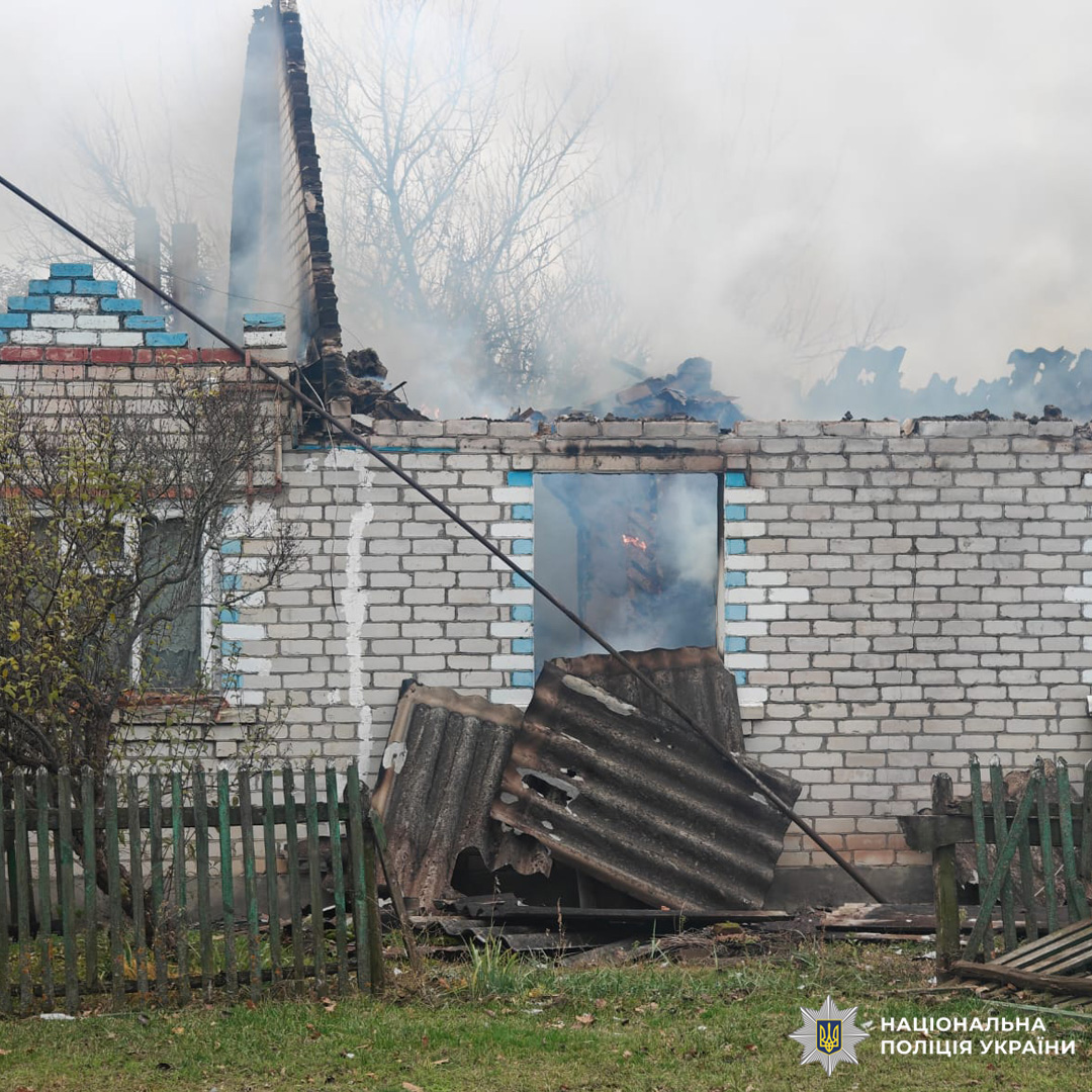 Пошкоджена будівля вночі: частково обвалений дах, відкриті сині металеві двері, всередині меблі. На землі уламки конструкцій.