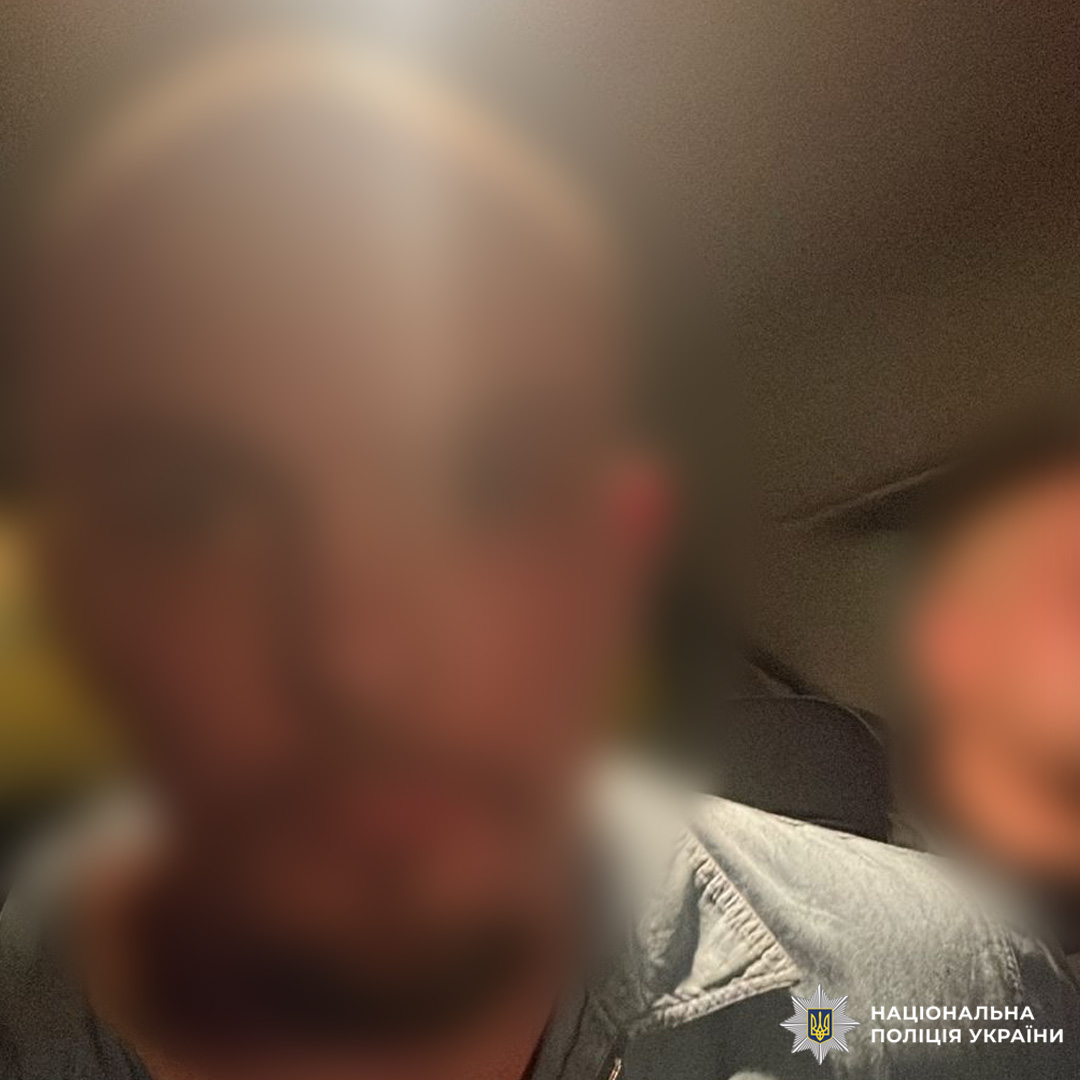 Двоє осіб із розмитими обличчями. Фото зроблено в приміщенні або транспортному засобі при слабкому освітленні.