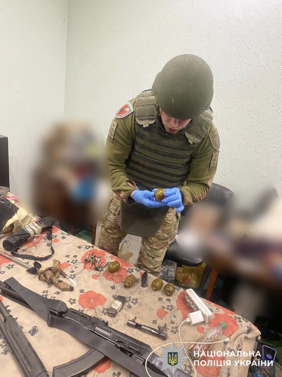 На фото поліцейький вилучає зброю у затриманого.