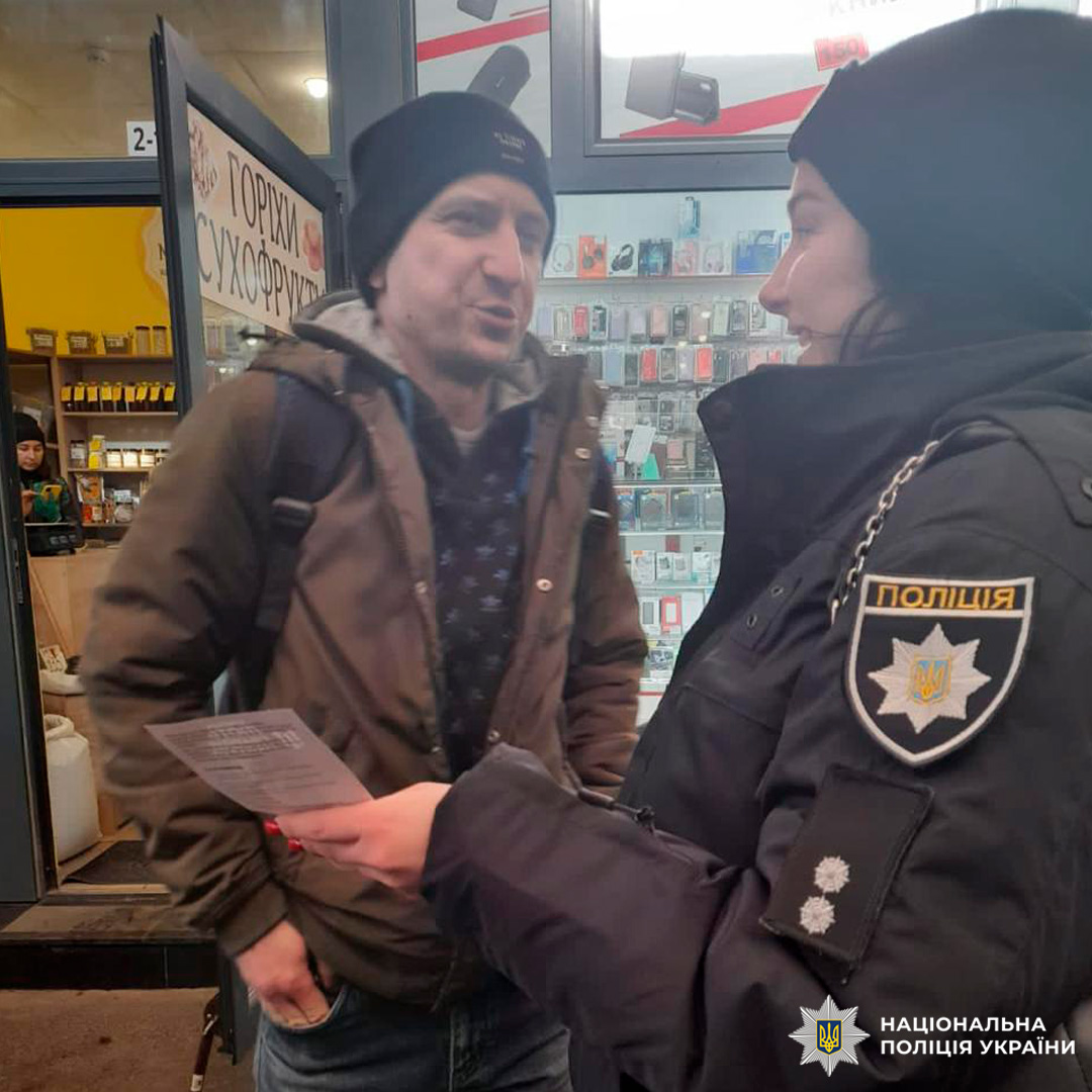 Поліцейський спілкується з чоловіком біля магазину.