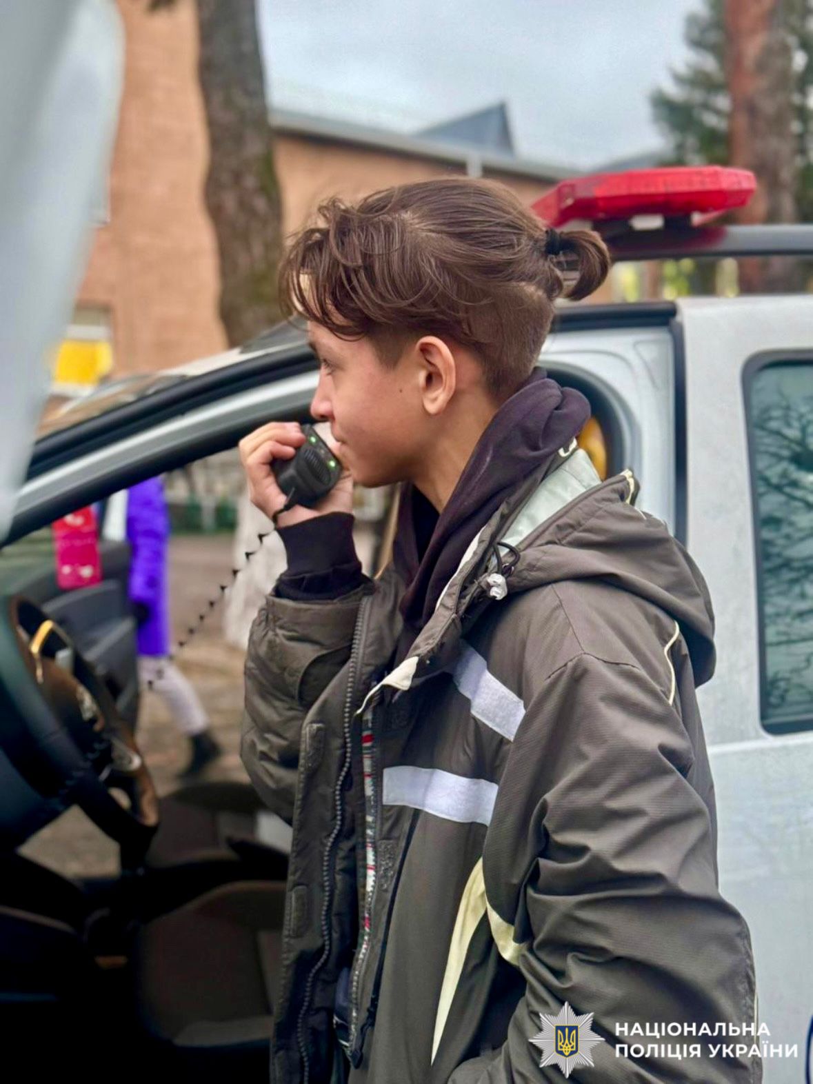 На фотографії зображено дитину, яка знайомиться зі спорядженням службового автомобіля.