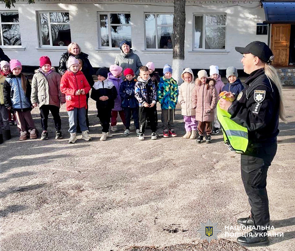 Ювенальна поліцейська розповідає дітям поради, як бути помітними в темну пору доби.