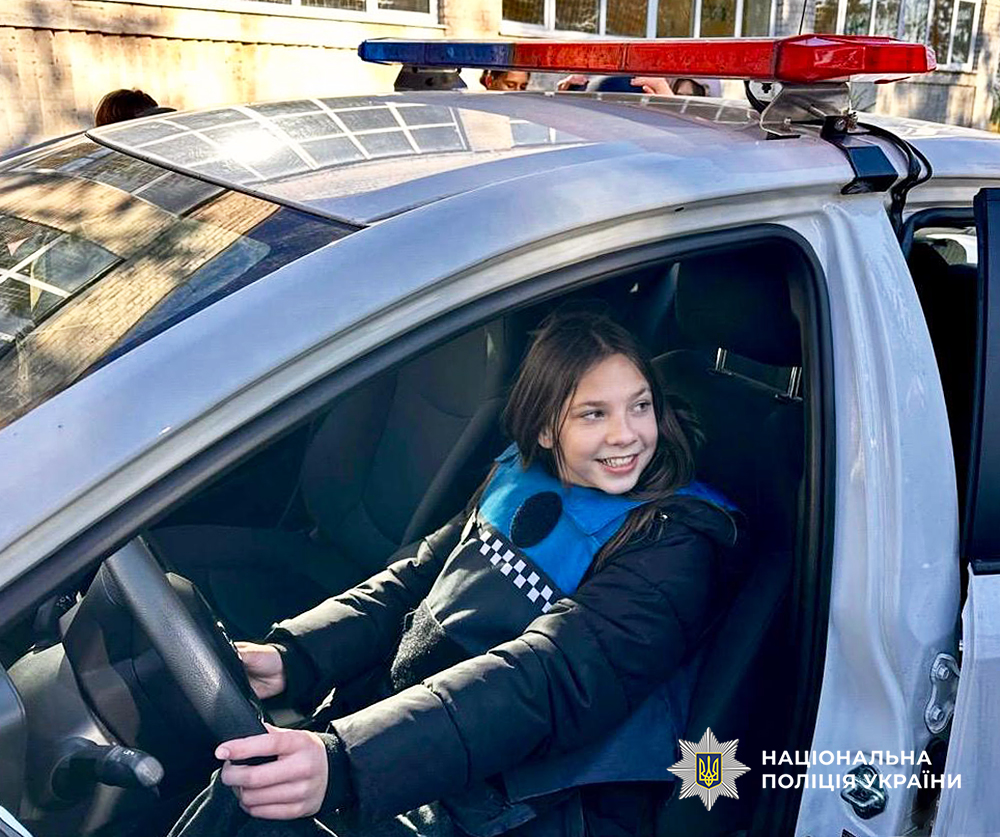 Дівчинка фотографується за кермом службового авто.