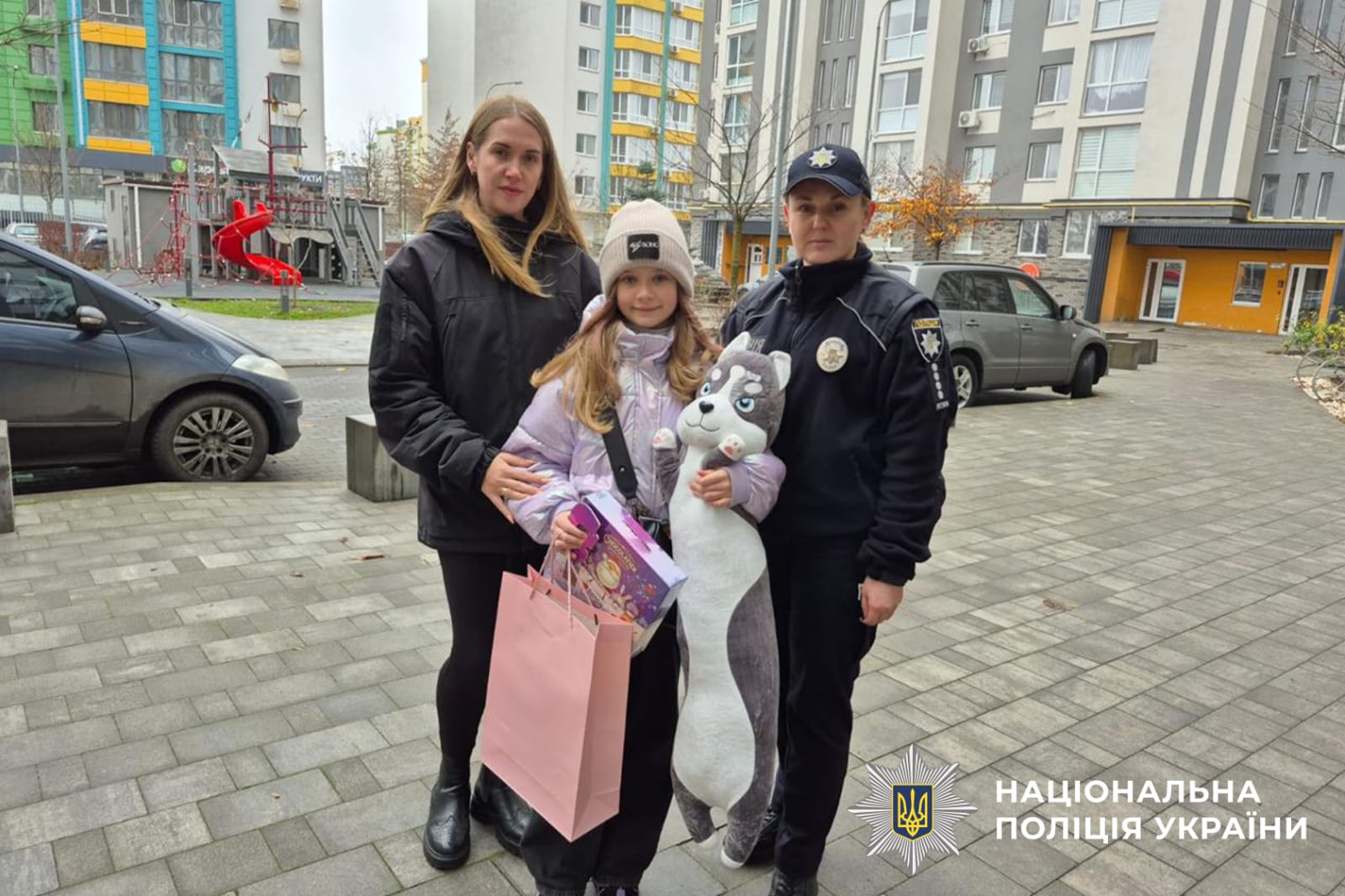 На фото зображені поліцейська та дитина з матір'ю.