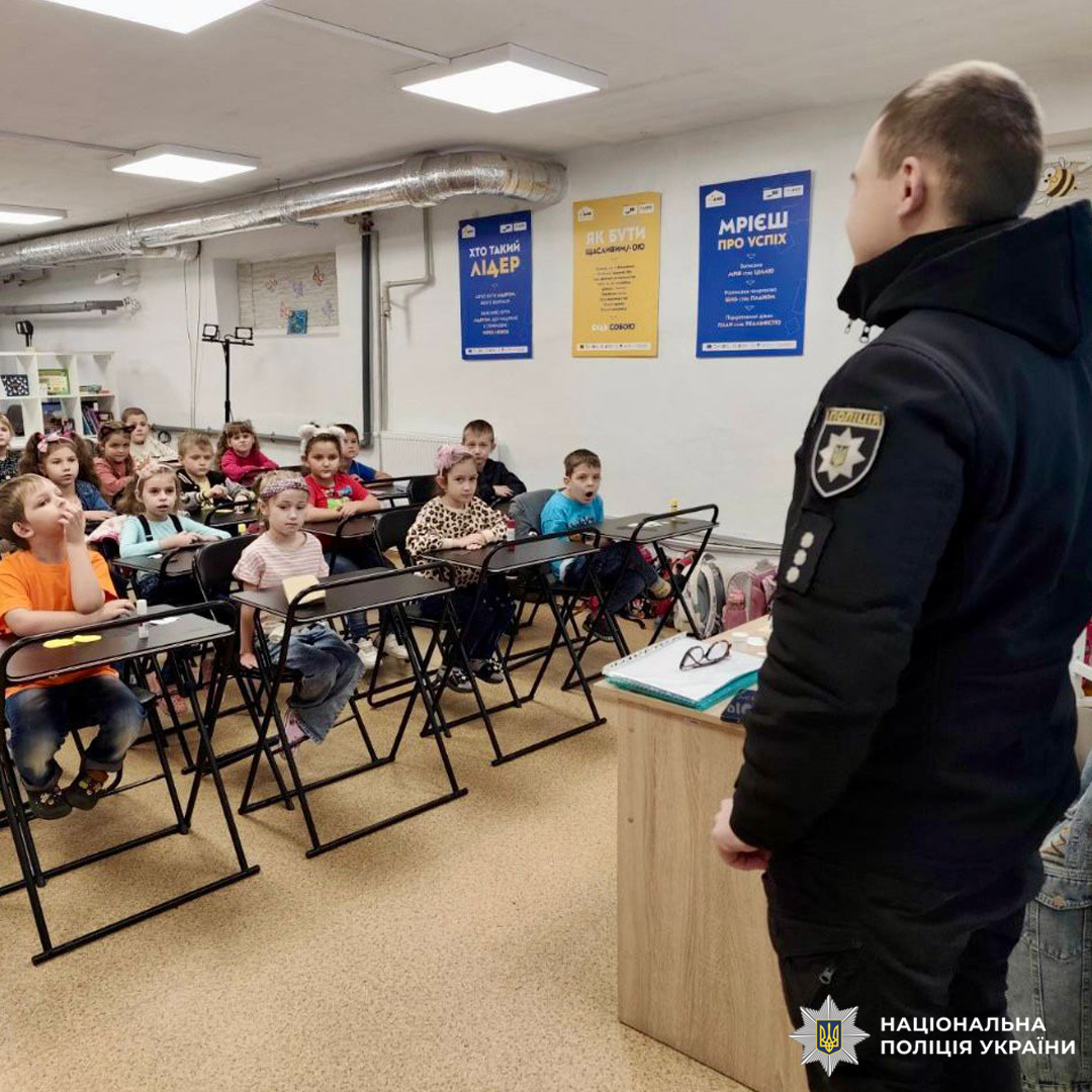 Поліцейський спілкується з дітьми в класі. Освітній захід про безпеку та правосвідомість.