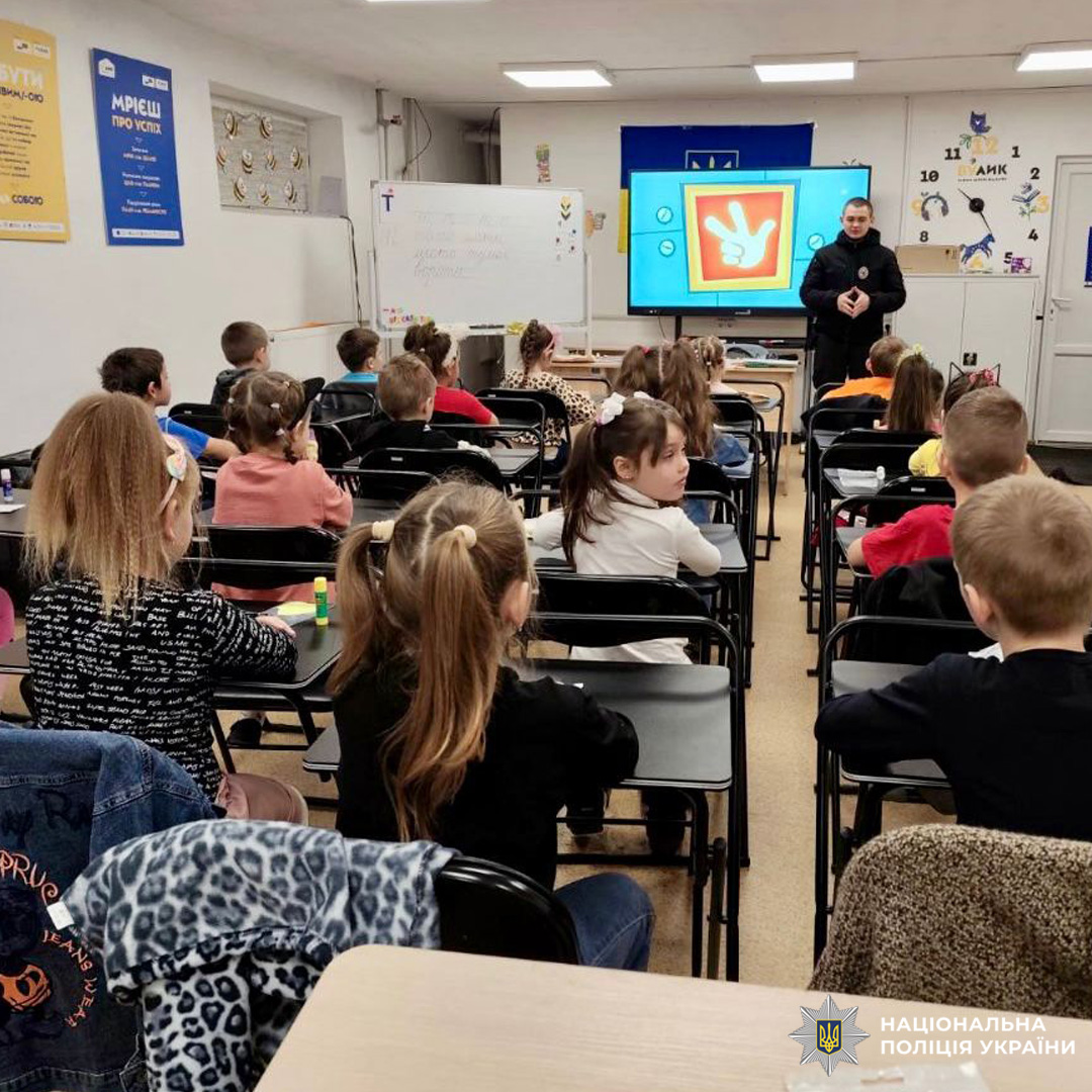 Поліцейський спілкується з дітьми в класі. Освітній захід про безпеку та правосвідомість.