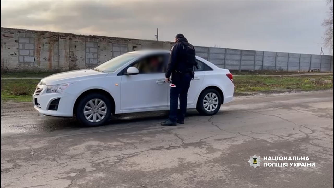 Поліцейський наголошує водію на дотриманні ПДР