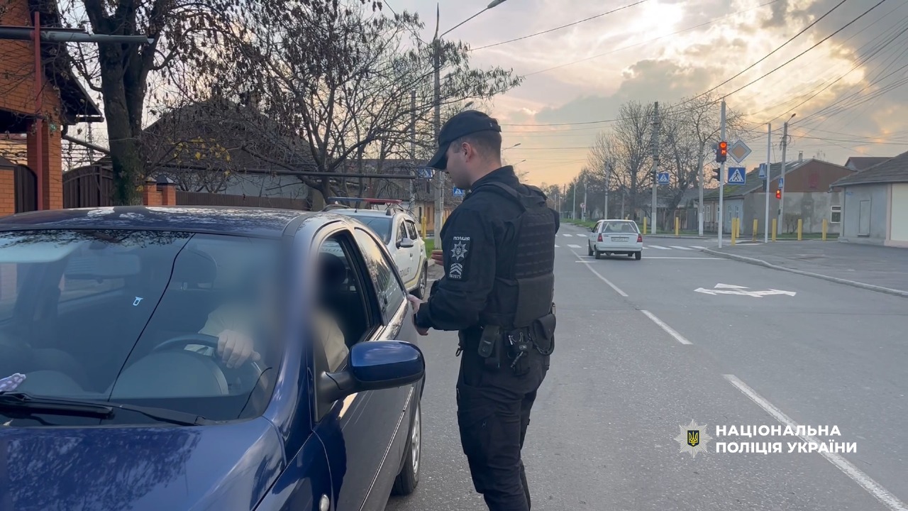 Поліцейський наголошує водію на дотриманні ПДР