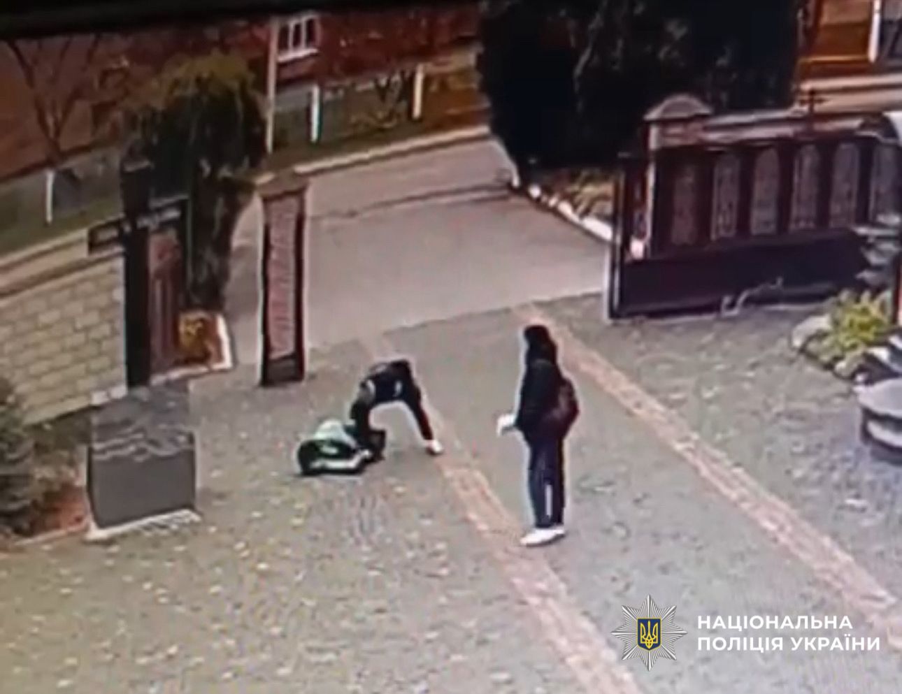 На фото зображений знімок з камери спостерження, на якому зловмисник напав на жінку.