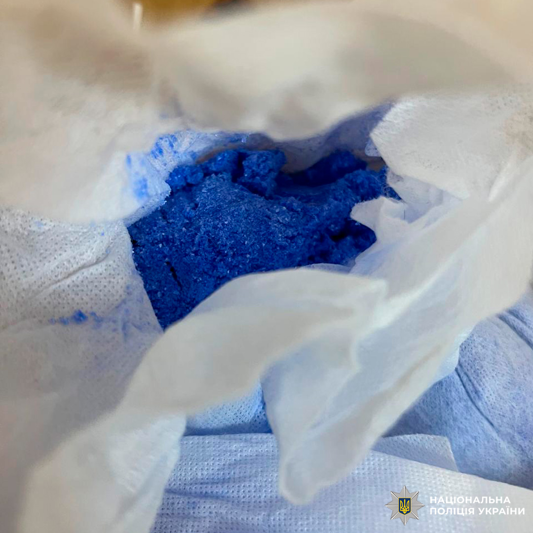 Під час слідчих дій вилучено речовину синього кольору з кристалічною або порошкоподібною структурою, розміщену на білому текстильному матеріалі.