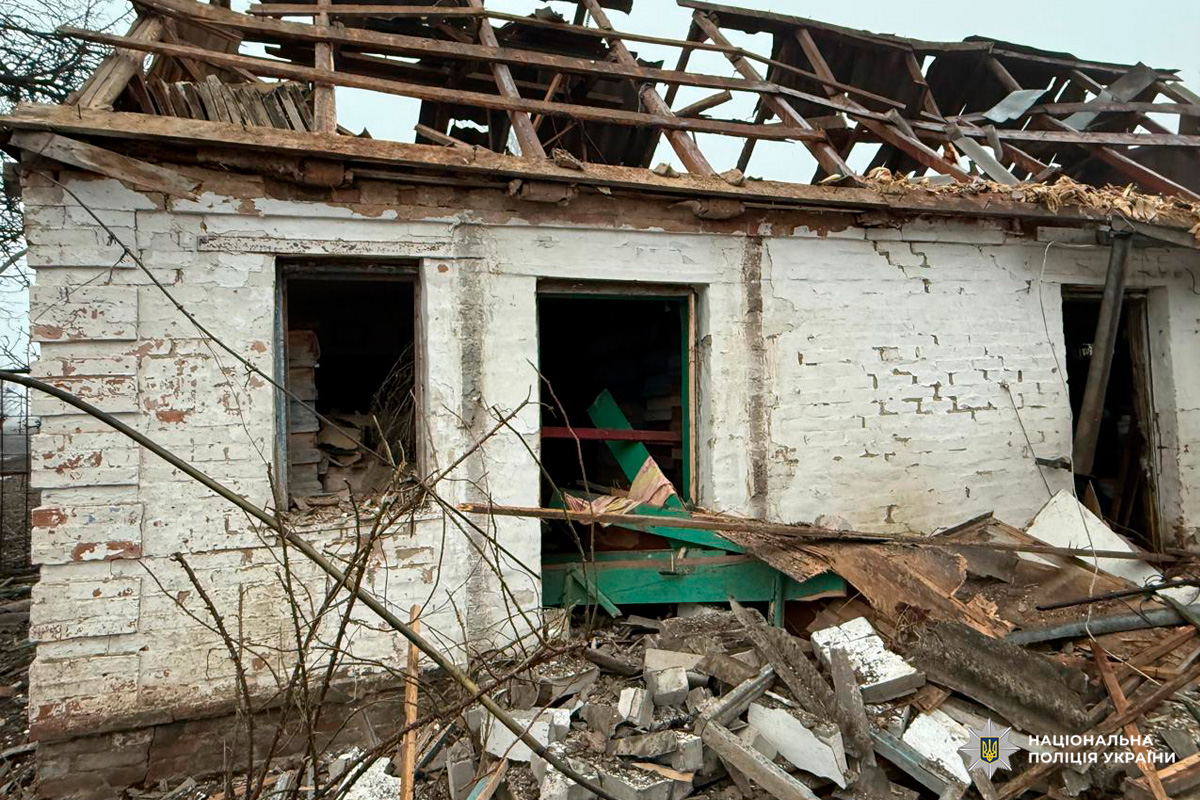 Зруйнований будинок із обваленим дахом і розбитими вікнами. Навколо уламки та хаос.