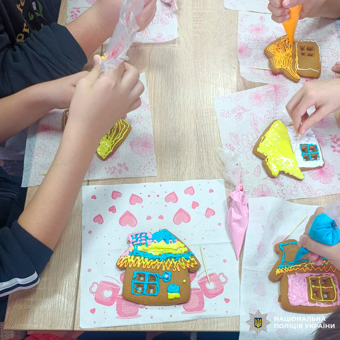 У класному приміщенні група дітей бере участь у майстер-класі з декорування пряників. Кожна дитина працює з кольоровою глазур’ю, створюючи візерунки на фігурних печивах.
