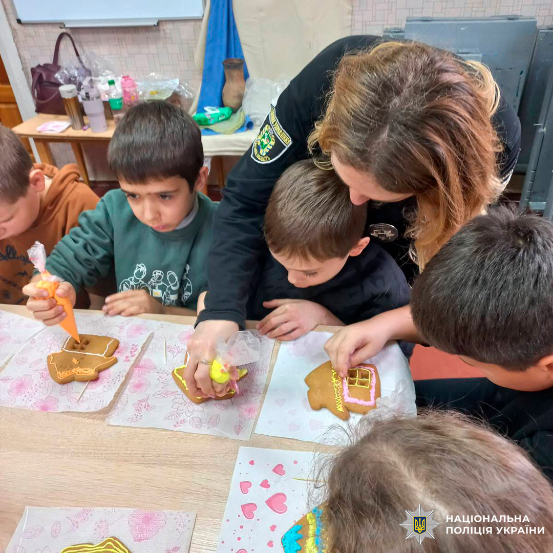 У класному приміщенні група дітей бере участь у майстер-класі з декорування пряників. Кожна дитина працює з кольоровою глазур’ю, створюючи візерунки на фігурних печивах.