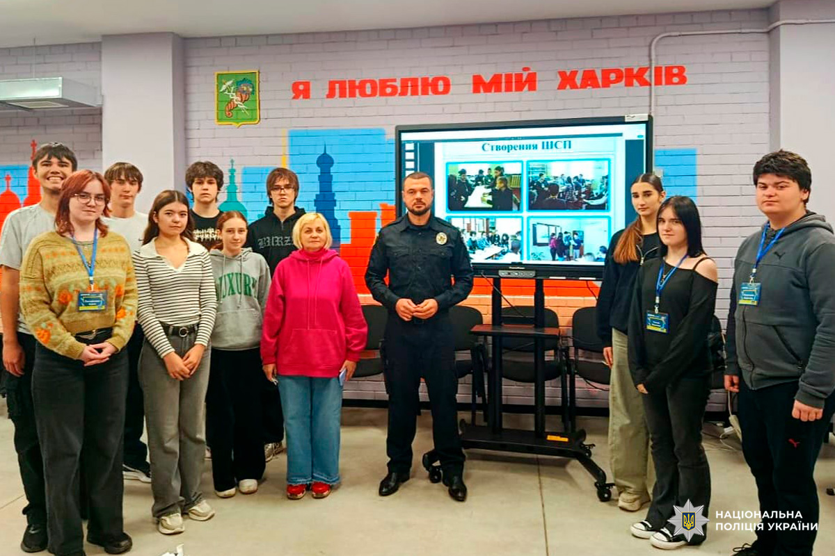 Група молоді та поліцейський беруть участь у проєкті «Шкільна служба порозуміння», в приміщенні з написом «Я люблю мій Харків».