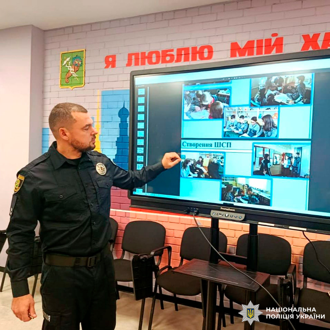 Співробітник Національної поліції України проводить лекцію для групи молодих людей. Учасники уважно слухають, деякі роблять нотатки.