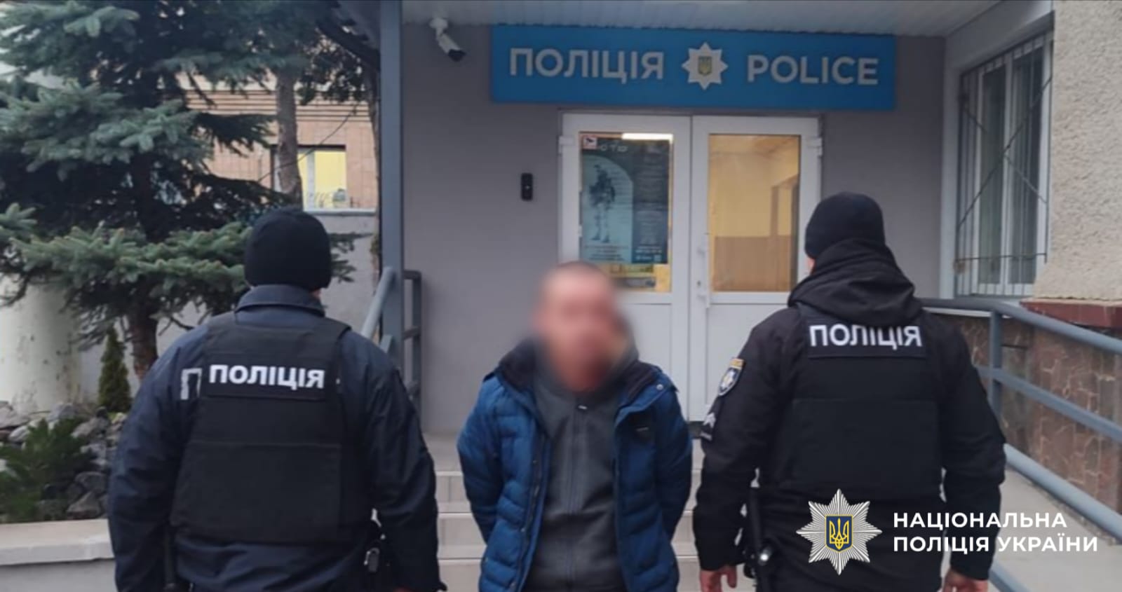 На фото зображено затриману особу разом з поліцейськими.