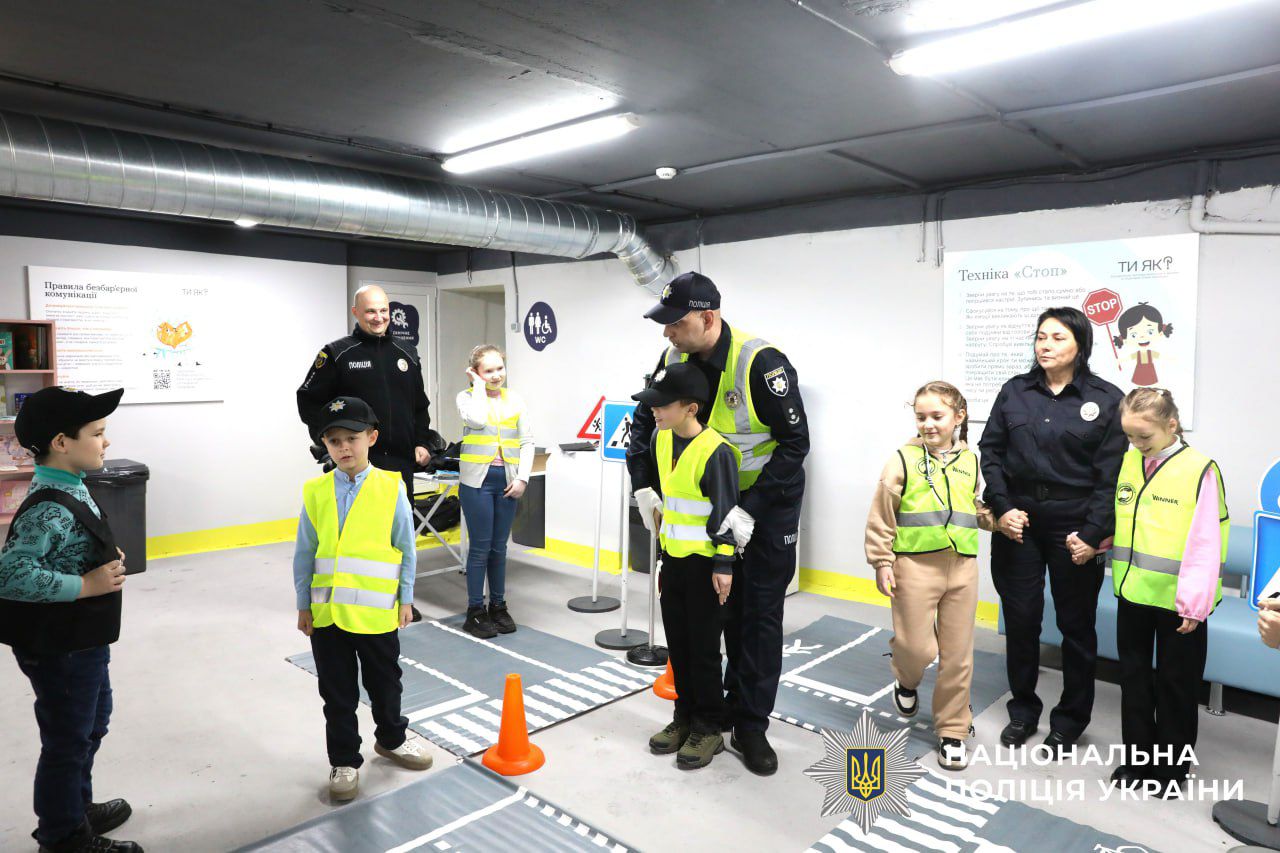 На фото зображено діти разом з поліцейським.