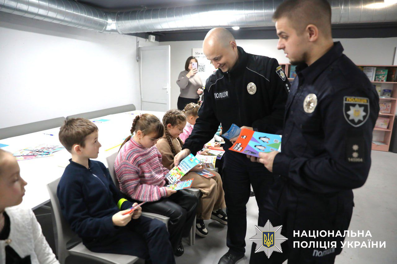 На фото зображено дітей разом з поліцейськими.