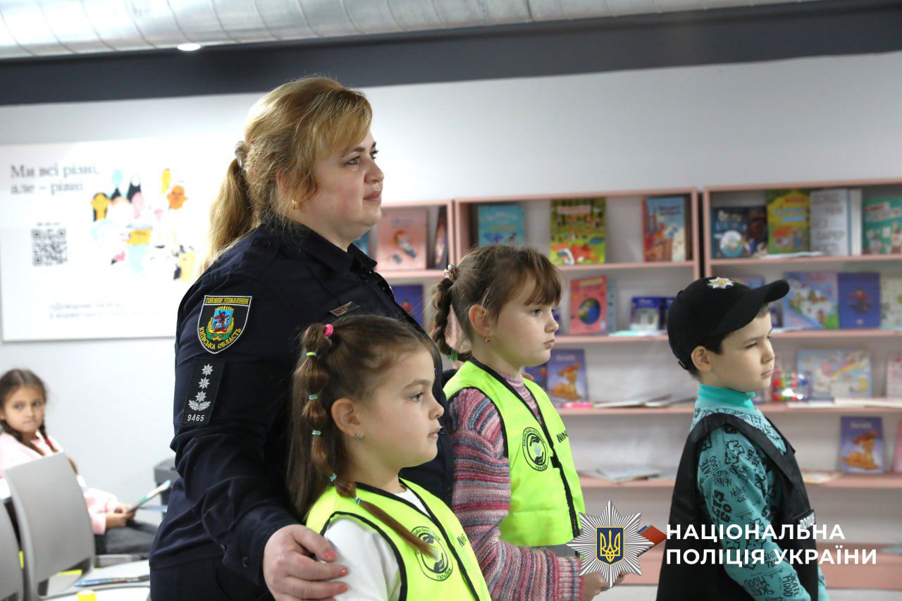 На фото зображено діти разом з поліцейським.