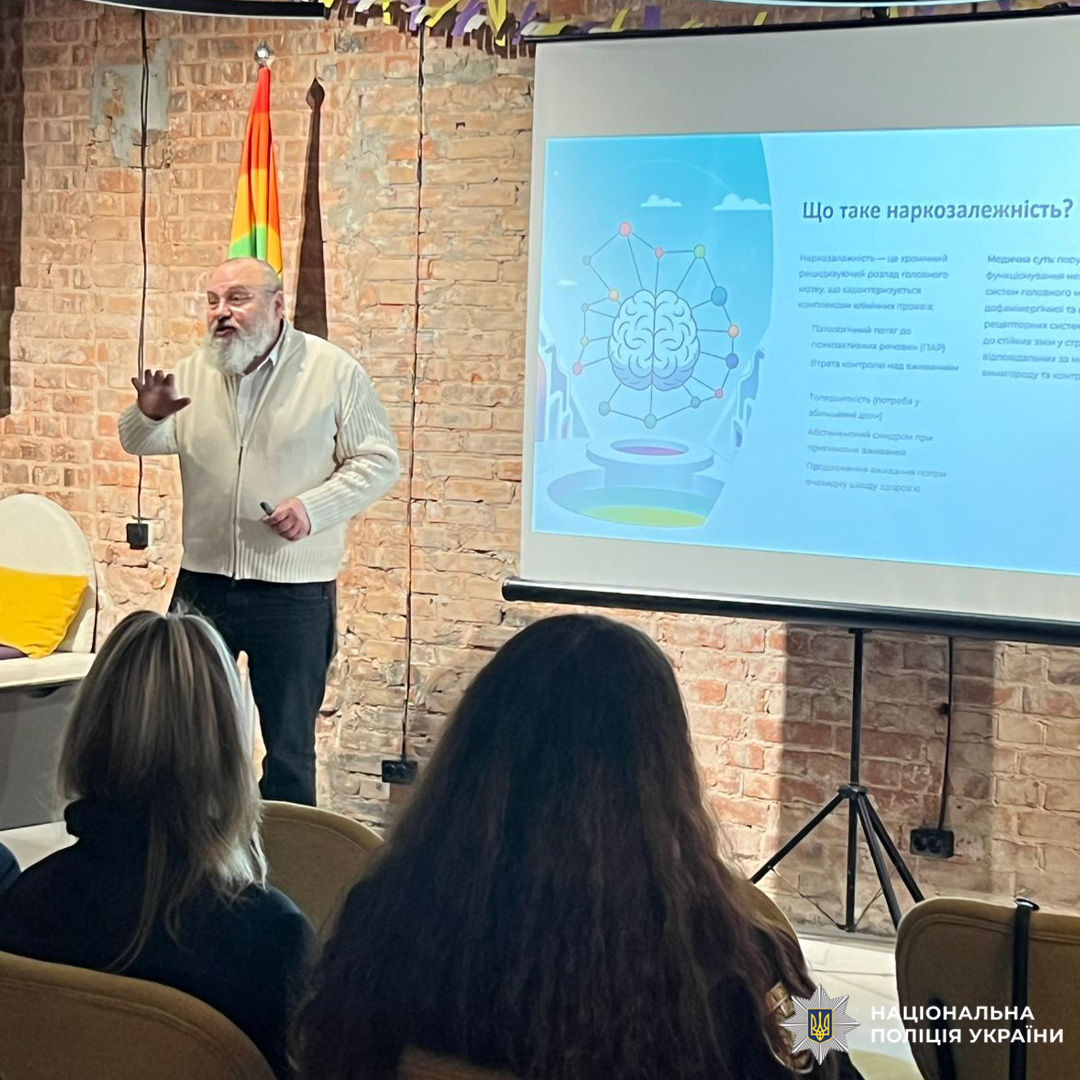 Чоловік пояснює, як наркотики змінюють мозок і поведінку; аудиторія слухає зосереджено.