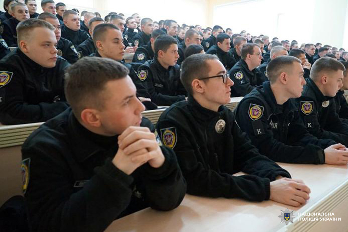 Курсанти Національної поліції України в навчальній аудиторії під час лекції; усі в форменому одязі, уважно слухають викладача.