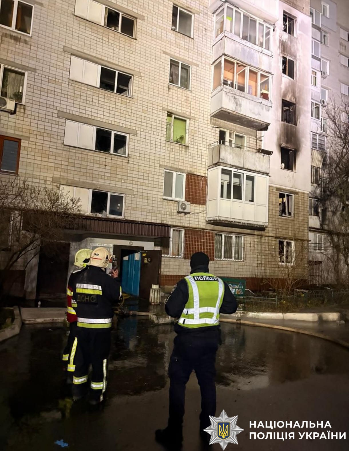 На фото зображено поліцейських та пошкоджений будинок