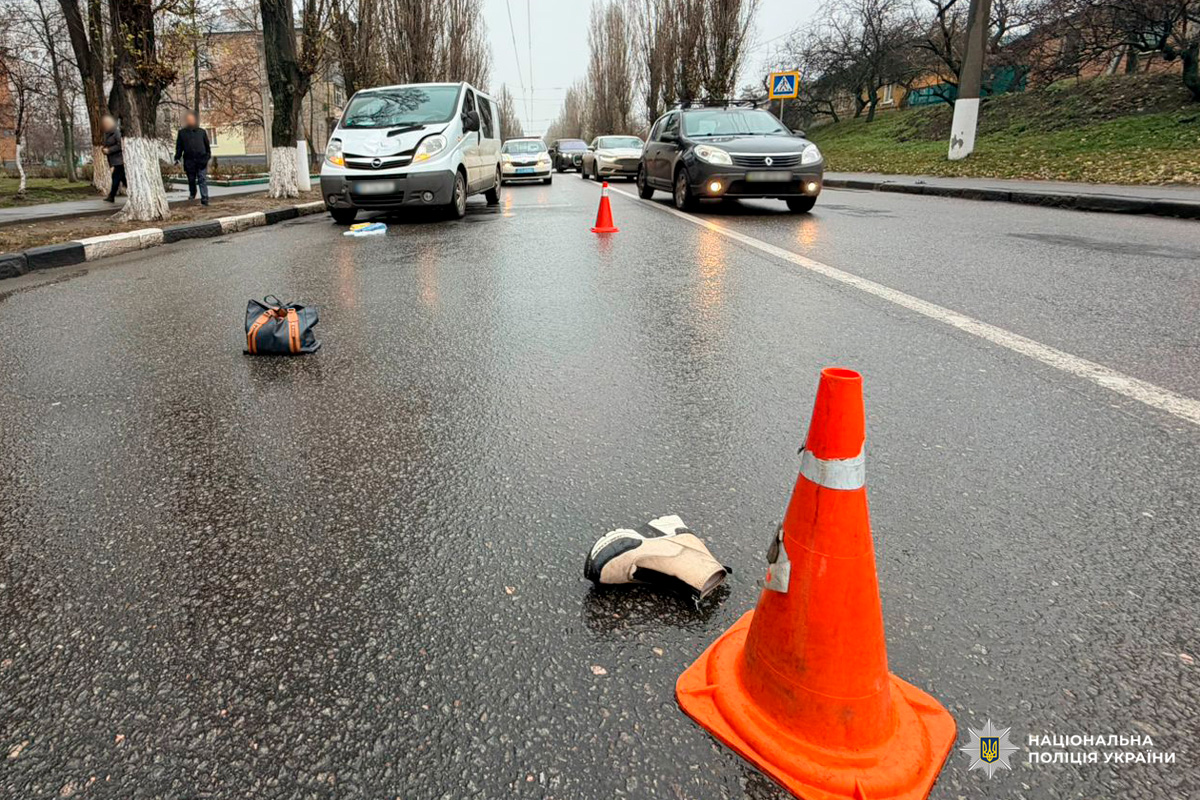 На зображенні зафіксовано ділянку дороги з ознаками можливої події: зупинені транспортні засоби, дорожні конуси, особисті речі на проїжджій частині.