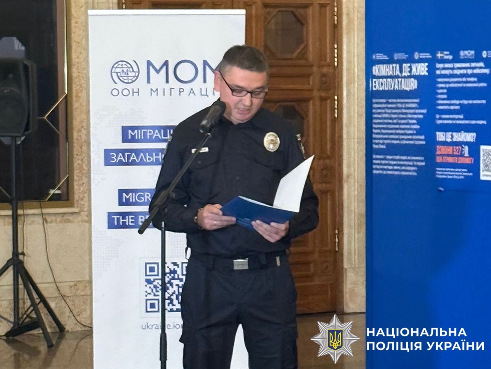 На фото поліцейський виступає перед учасниками зустрічі.