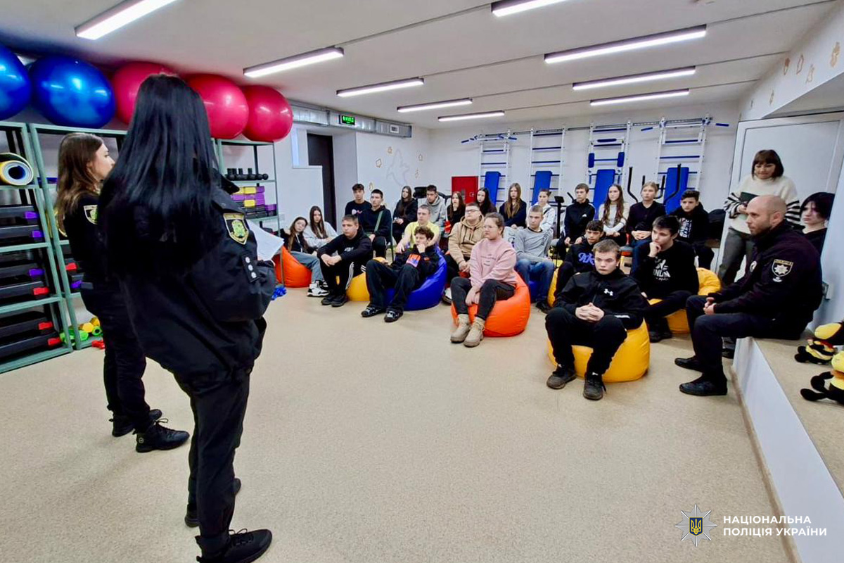 Поліцейські розповідають підліткам про навчання у закладах вищої освіти системи МВС, у яскраво оформленому приміщенні.