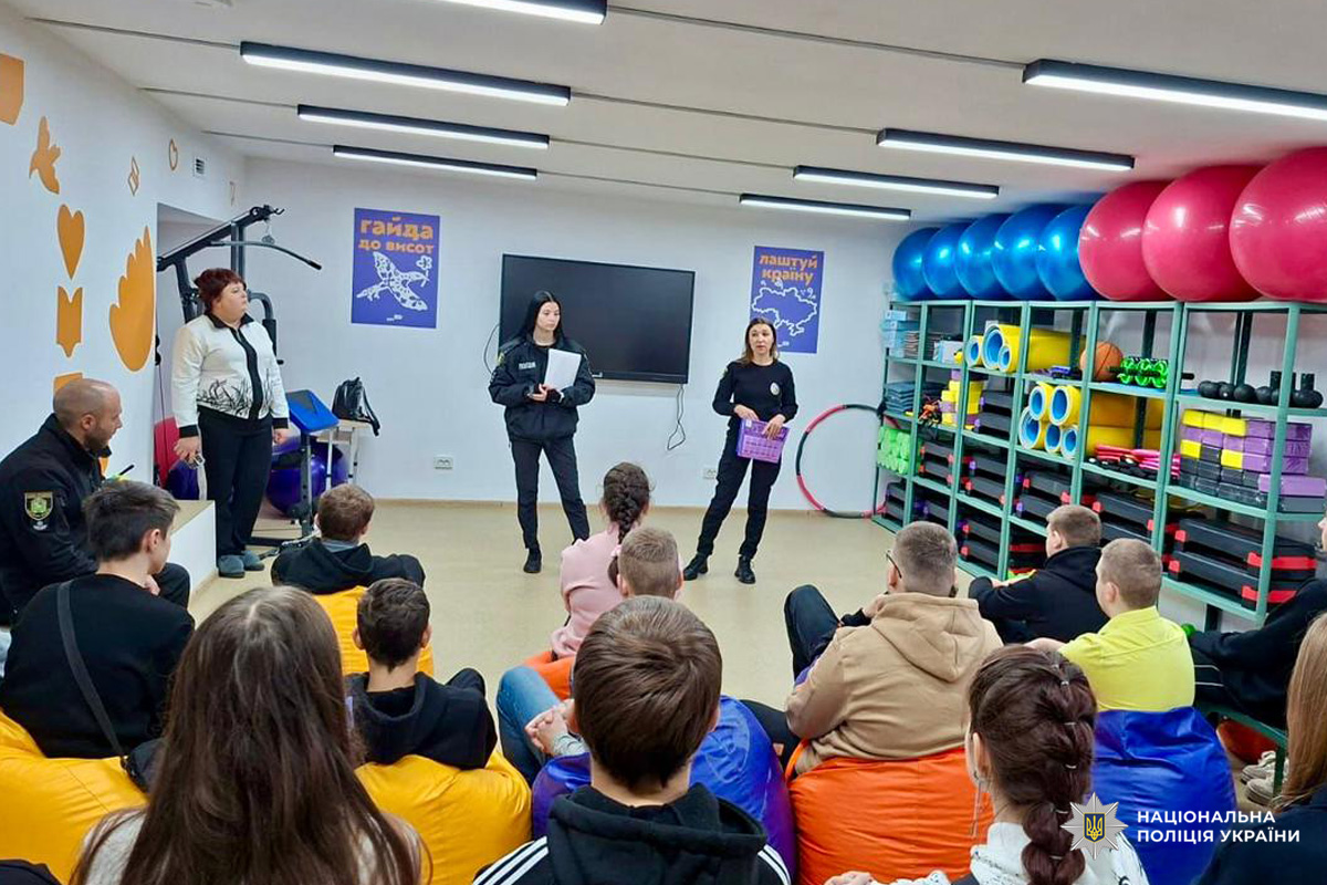 Поліцейські розповідають підліткам про навчання у закладах вищої освіти системи МВС, у яскраво оформленому приміщенні.