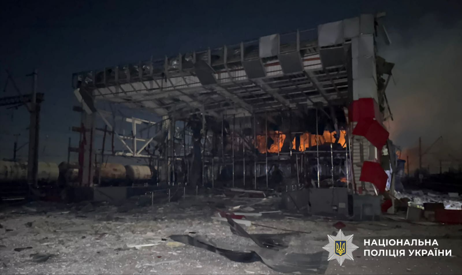 На фото зображено пошкоджену, палаючу будівлю.