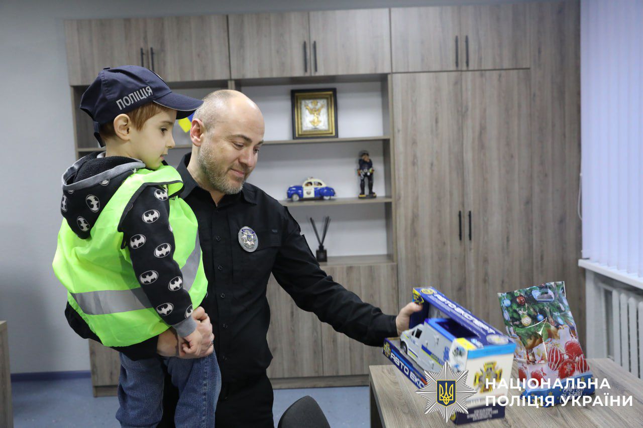 На фото зображено хлопчика разом з полыцейськими.