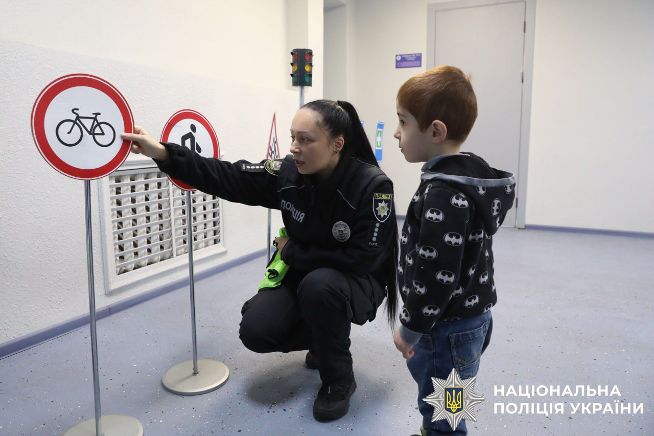 На фото зображено хлопчика разом з полыцейськими.