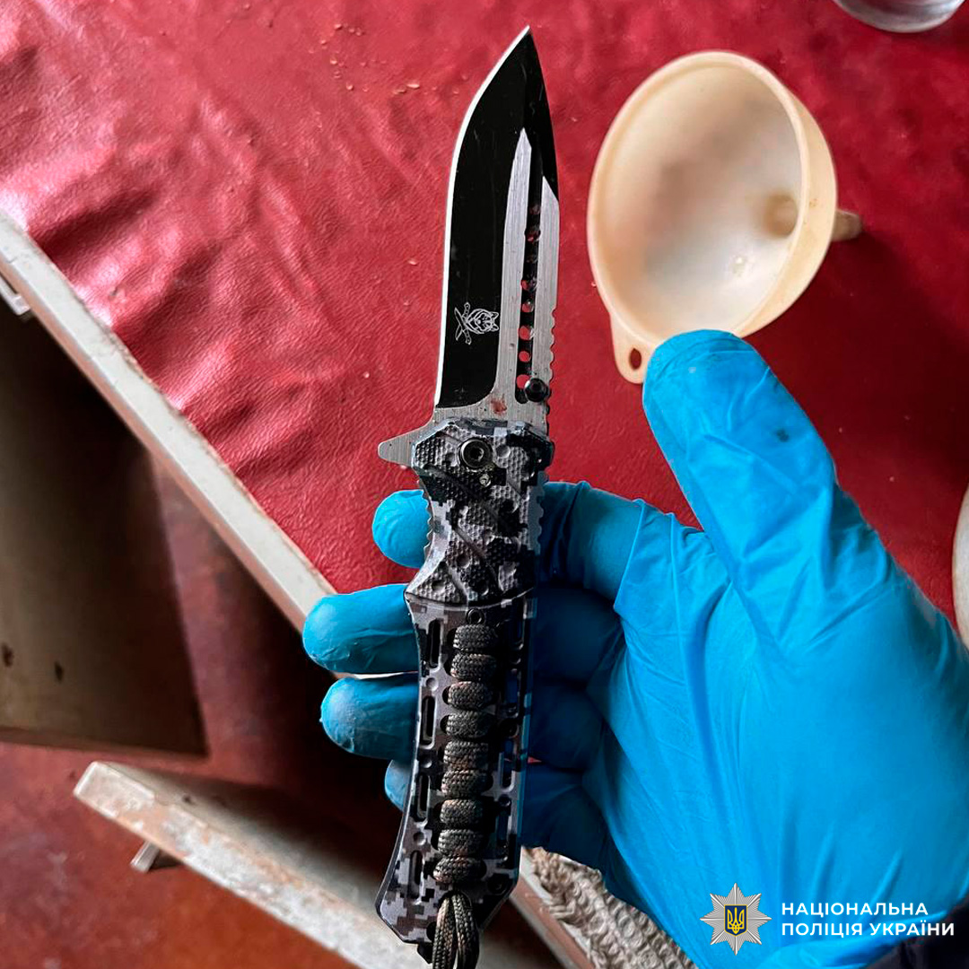 На зображенні зафіксовано складний ніж тактичного типу, який утримується рукою в нітриловій (оглядовій) рукавичці, що прямо вказує на процесуальний або слідчо-оперативний контекст.