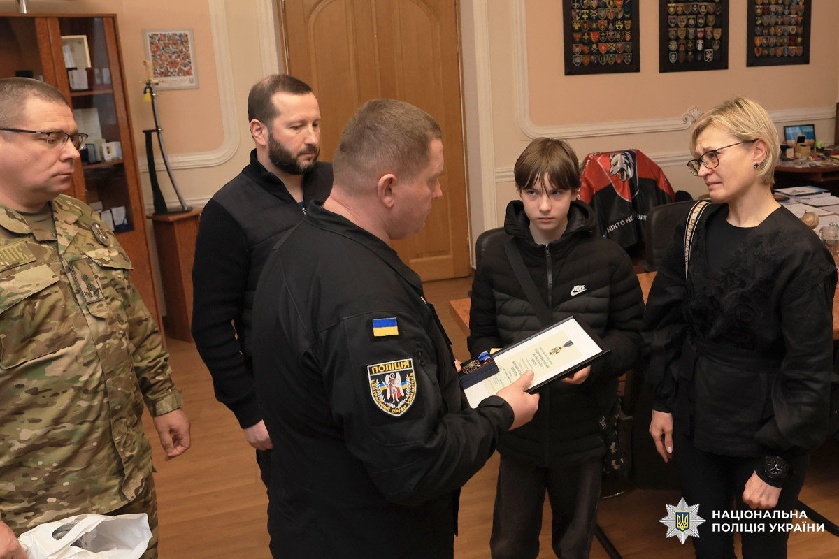 Начальник ГУНП у Хмельницькій області Руслан Герасимчук вручає нагороду матері та синові загиблого Героя Геннадія Лахмая